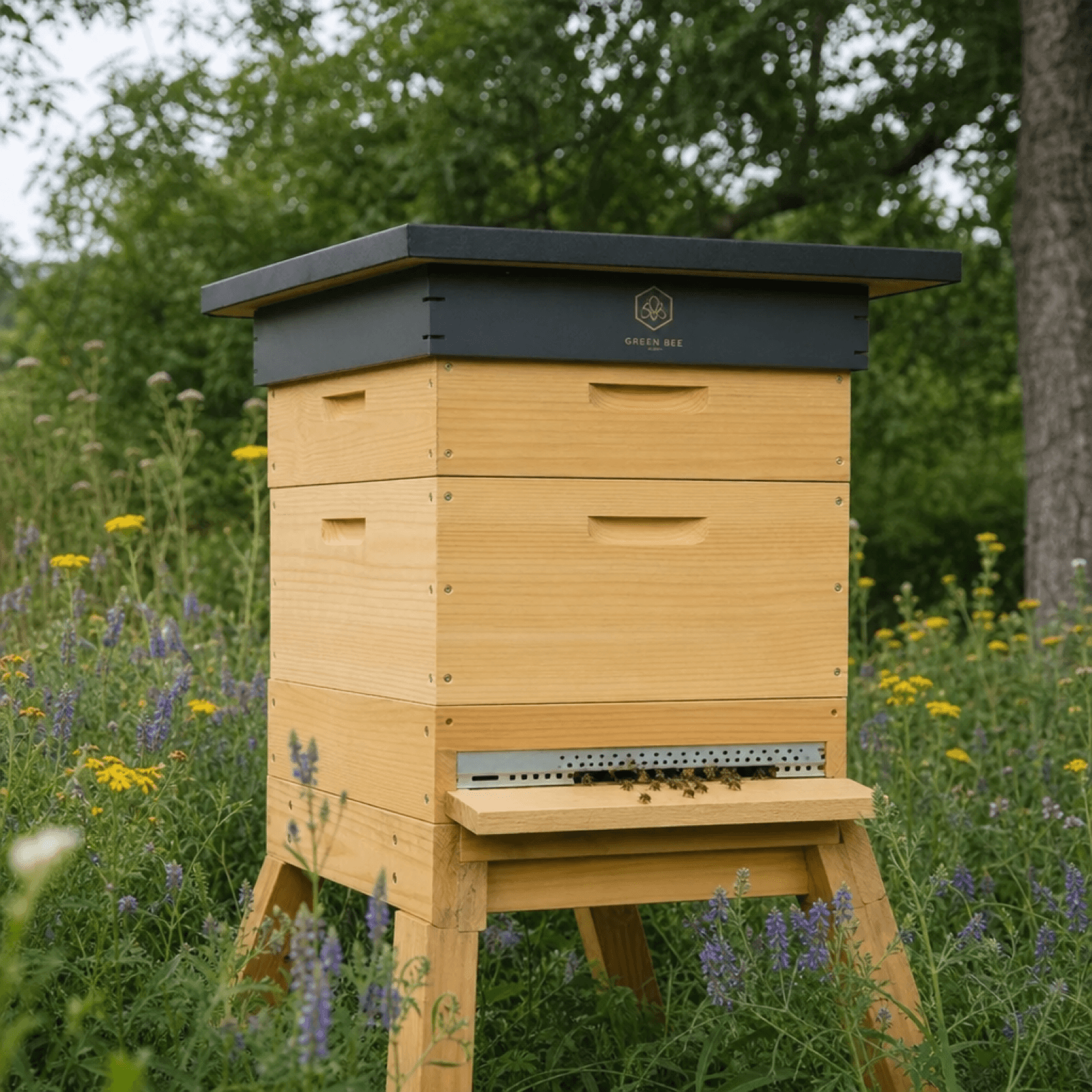 A modern wooden beehive with a dark roof standing in a meadow of wildflowers, bees visible at the entrance — an eco-friendly apiary in a natural setting.